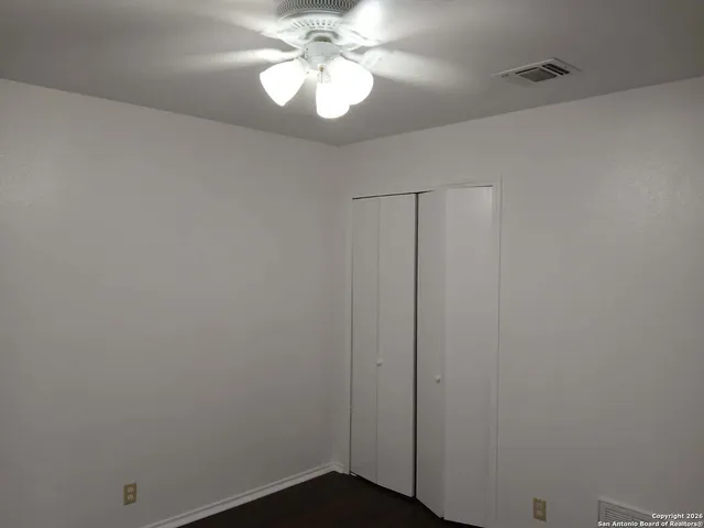 a view of a chandelier fan and hardwood floor