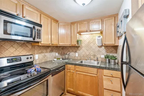 a kitchen with stainless steel appliances granite countertop a refrigerator and stove