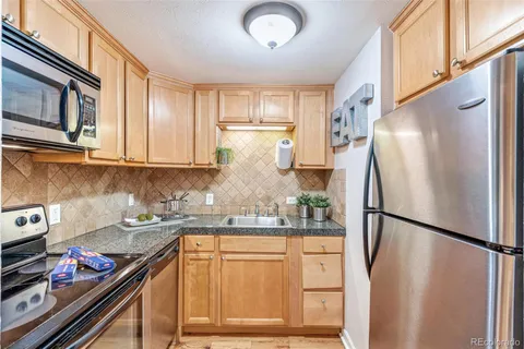a kitchen with stainless steel appliances granite countertop a refrigerator and a sink