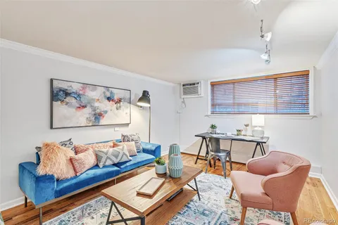 a living room with furniture a rug and a wall painting