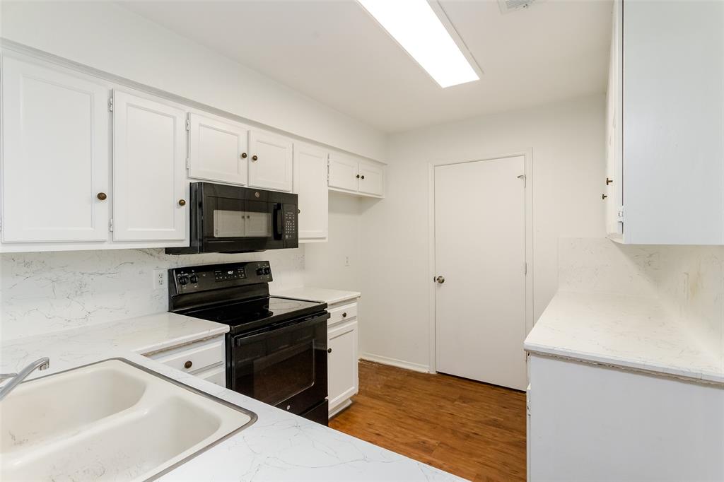 900 Milby Road Arlington, TX 76013 - Photo 18 of 28 a kitchen with granite countertop white cabinets and black appliances