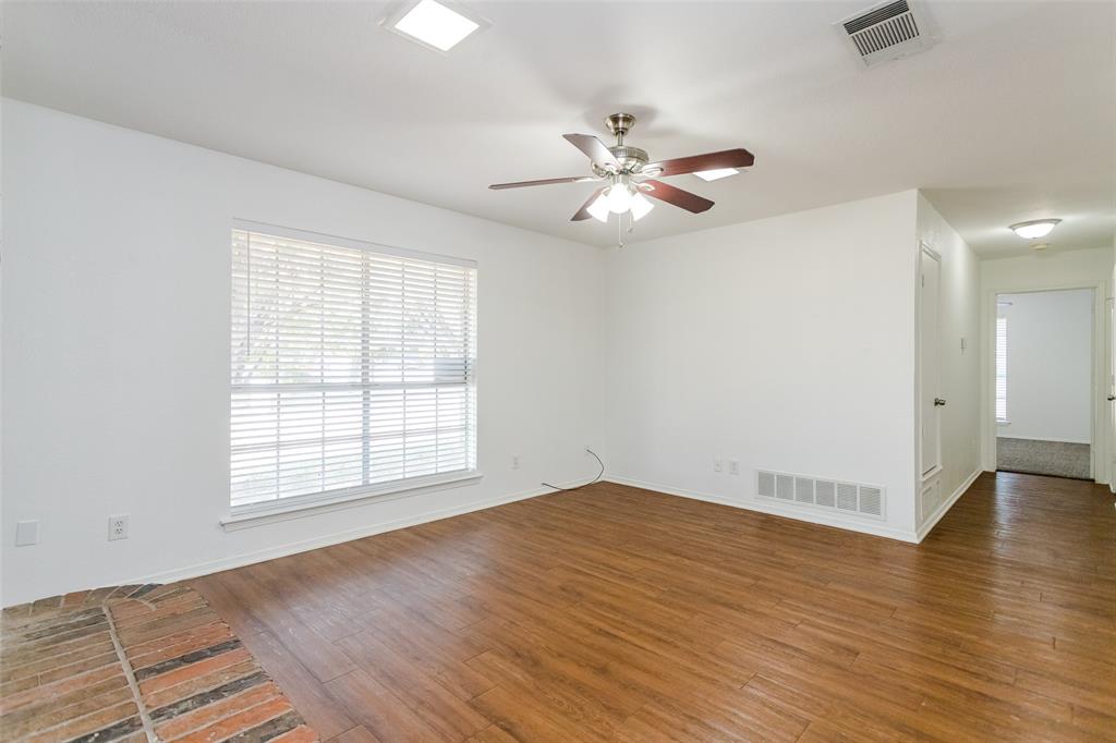 900 Milby Road Arlington, TX 76013 - Photo 5 of 28 an empty room with wooden floor fan and windows