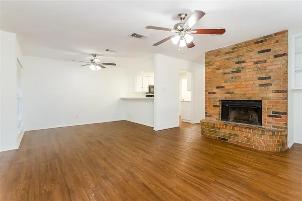 a view of empty room with wooden floor and fireplace