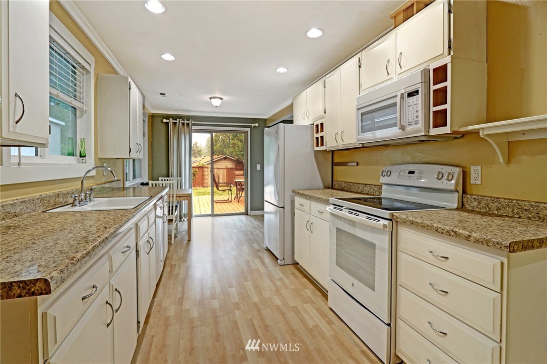 19670 Southeast 139th Place Renton, WA 98059 - Photo 9 of 25 a kitchen with stainless steel appliances granite countertop a lot of counter space and wooden floors