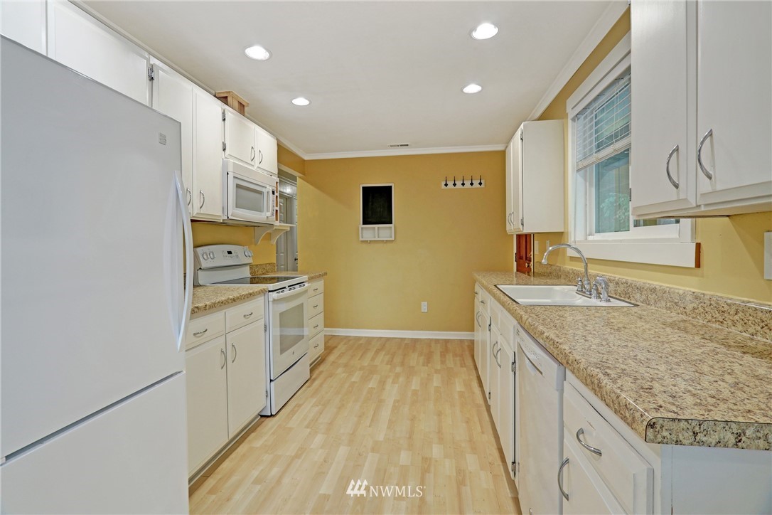19670 Southeast 139th Place Renton, WA 98059 - Photo 10 of 25 a kitchen with stainless steel appliances granite countertop a sink and cabinets with wooden floor