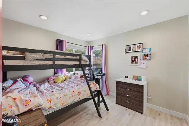 a bedroom with bed and wooden floor