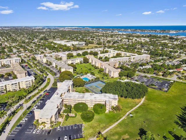 an aerial view of a city with lots of residential buildings ocean and mountain view in back