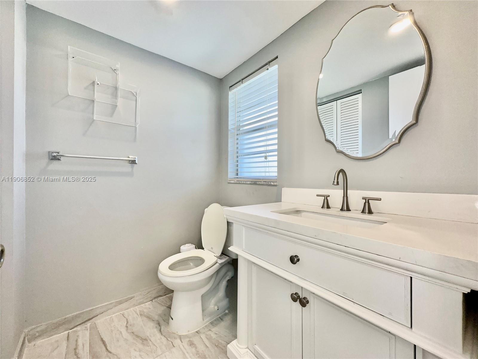 2520 Northeast 1st Court, Unit 204 Boynton Beach, FL 33435 - Photo 4 of 23 a bathroom with a sink a toilet and a mirror