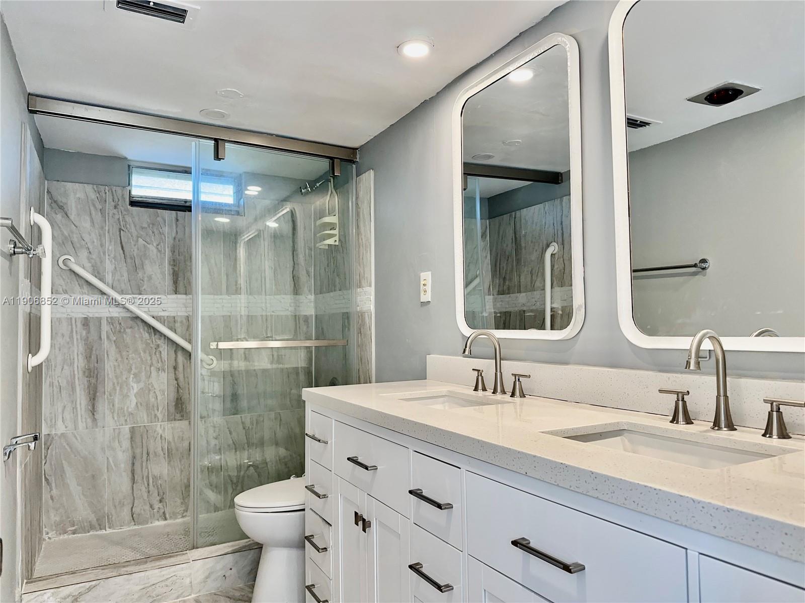2520 Northeast 1st Court, Unit 204 Boynton Beach, FL 33435 - Photo 8 of 23 a bathroom with a double vanity sink mirror and toilet