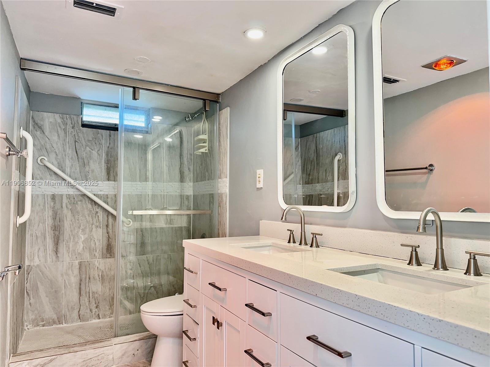 2520 Northeast 1st Court, Unit 204 Boynton Beach, FL 33435 - Photo 9 of 23 a bathroom with a granite countertop sink toilet and shower