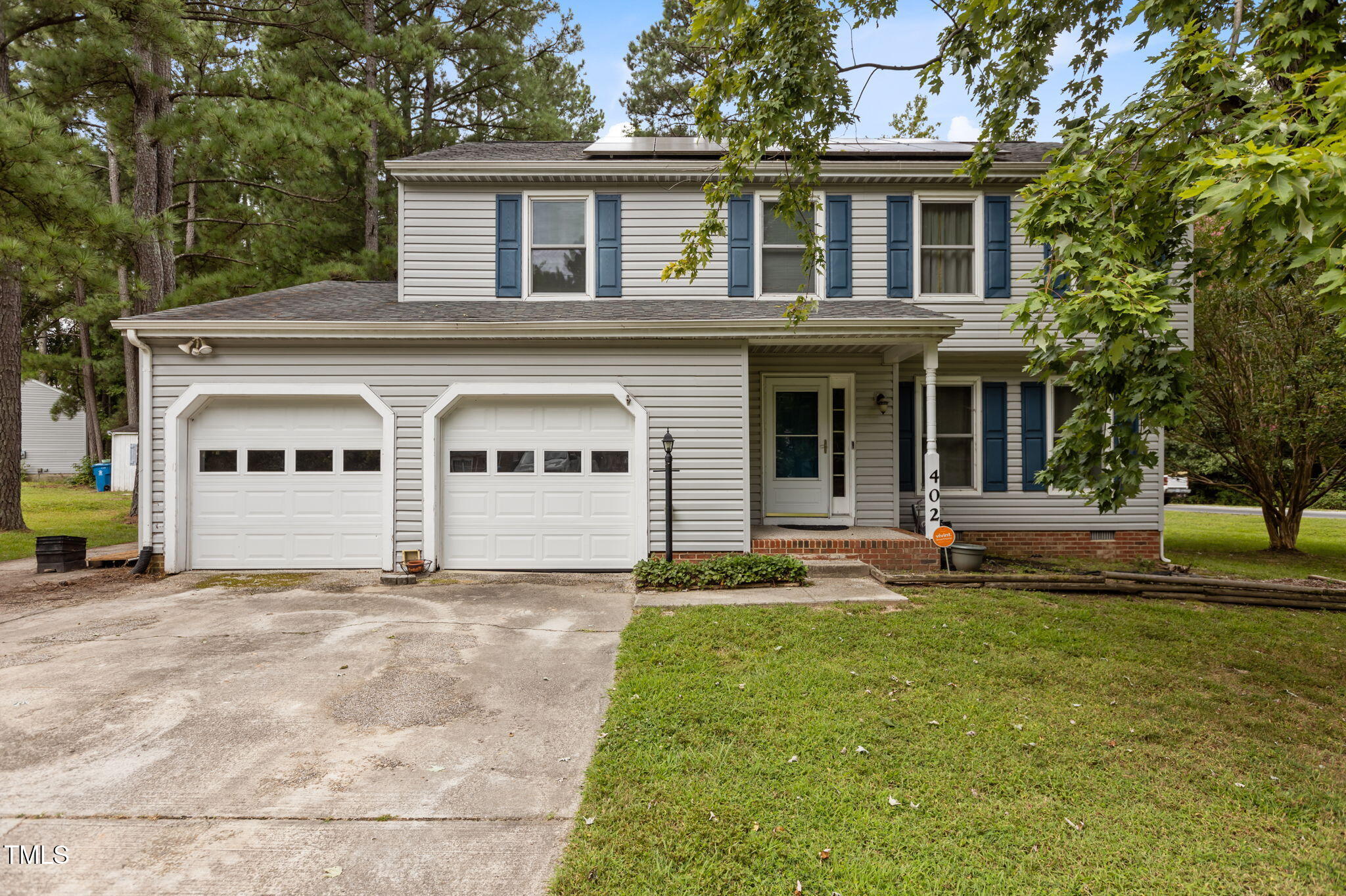 a view of a house with a yard and large tree