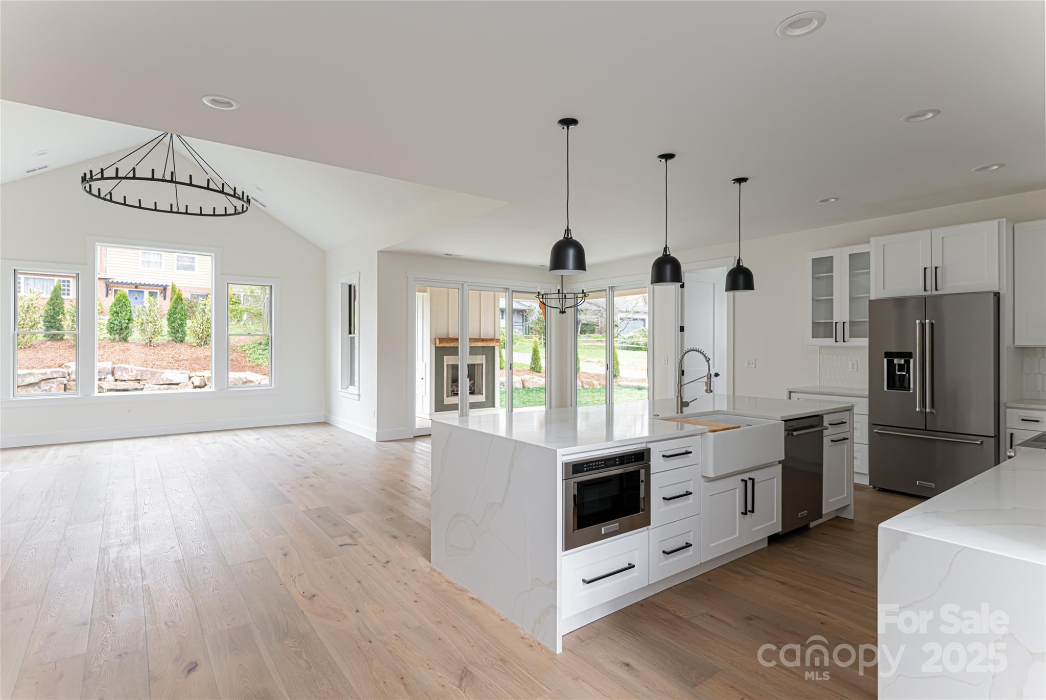 251 Bee Tree Road Swannanoa, NC 28778 - Photo 11 of 46 a large white kitchen with stainless steel appliances granite countertop a stove and a wooden floors