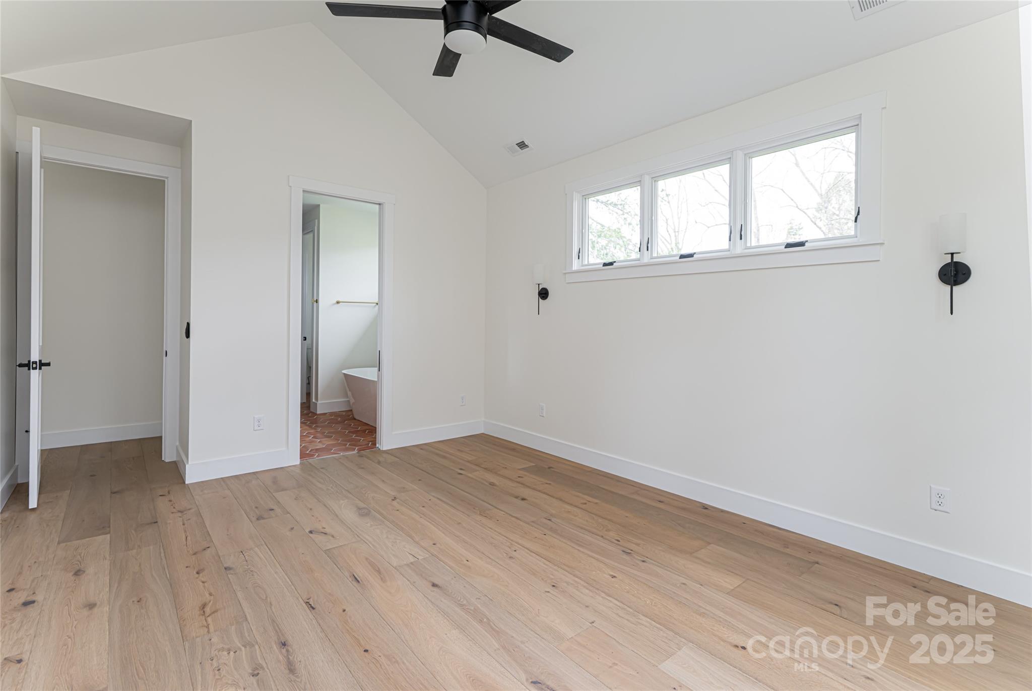 251 Bee Tree Road Swannanoa, NC 28778 - Photo 25 of 46 an empty room with wooden floor fan and windows