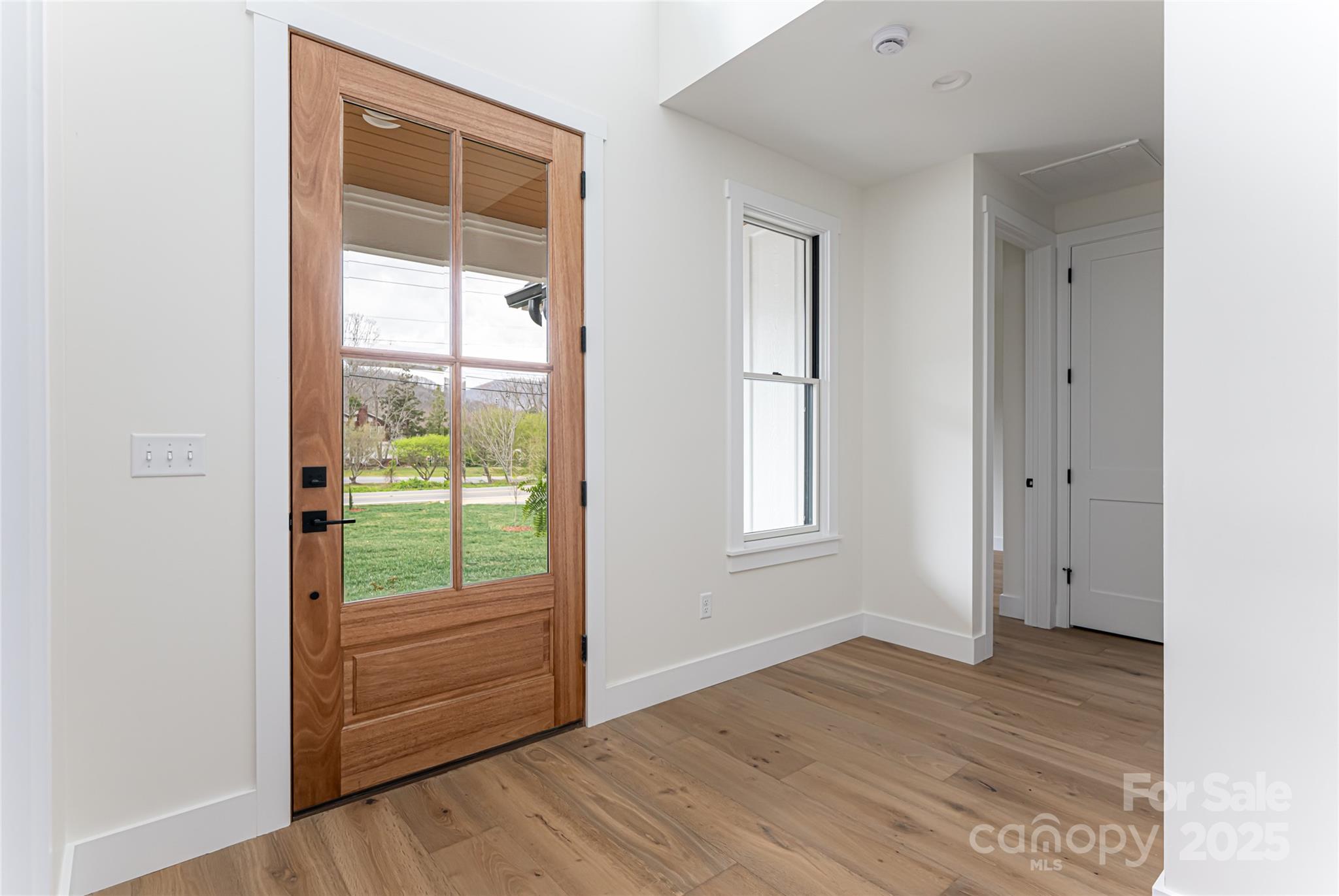 251 Bee Tree Road Swannanoa, NC 28778 - Photo 9 of 46 an empty room with wooden floor and windows