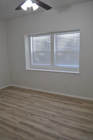 a view of a room that has wooden floor and a window