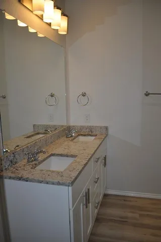 a bathroom with a granite countertop sink and a mirror