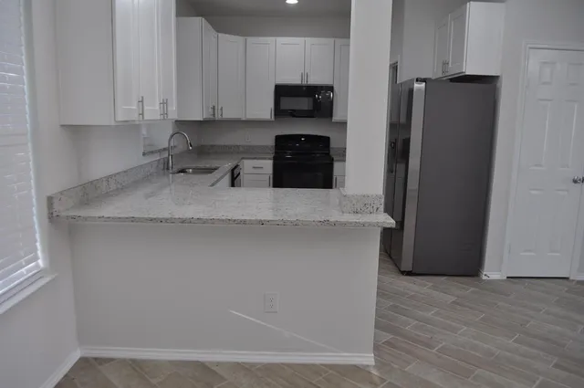 a kitchen with stainless steel appliances granite countertop a refrigerator a stove a sink and a granite counter tops