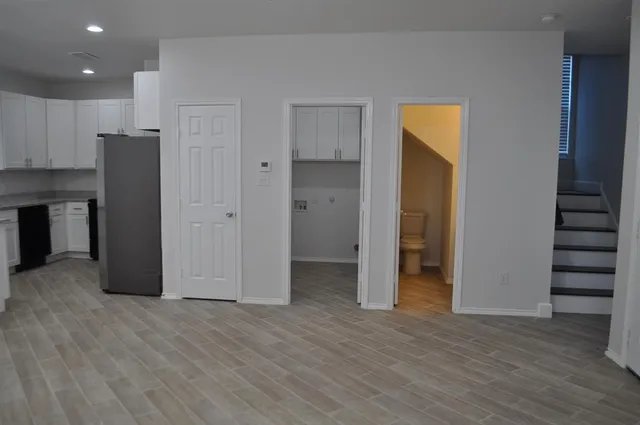 a kitchen with stainless steel appliances granite countertop a refrigerator a sink dishwasher a stove and a wooden floors