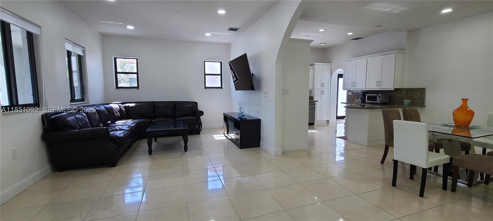 1721 Southwest 24th Terrace Miami, FL 33145 - Photo 5 of 80 a living room with furniture a flat screen tv and kitchen view