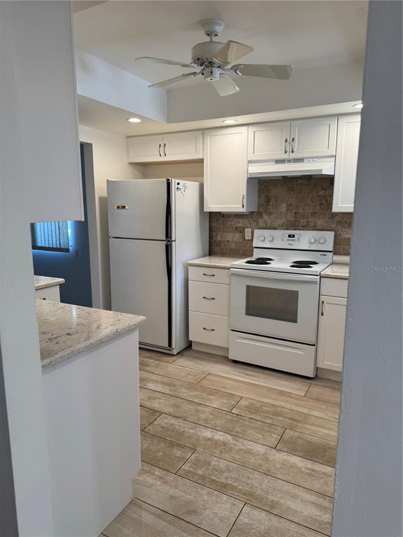 3957 Lakeside Way, Unit 143 Sarasota, FL 34232 - Photo 4 of 26 a kitchen with a stove a refrigerator and a sink