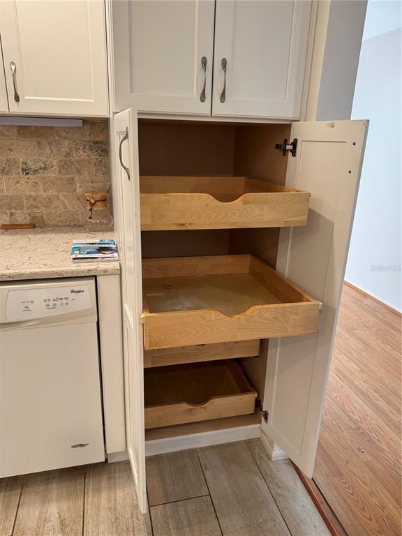 3957 Lakeside Way, Unit 143 Sarasota, FL 34232 - Photo 5 of 26 a view of washer and dryer with wooden cabinets