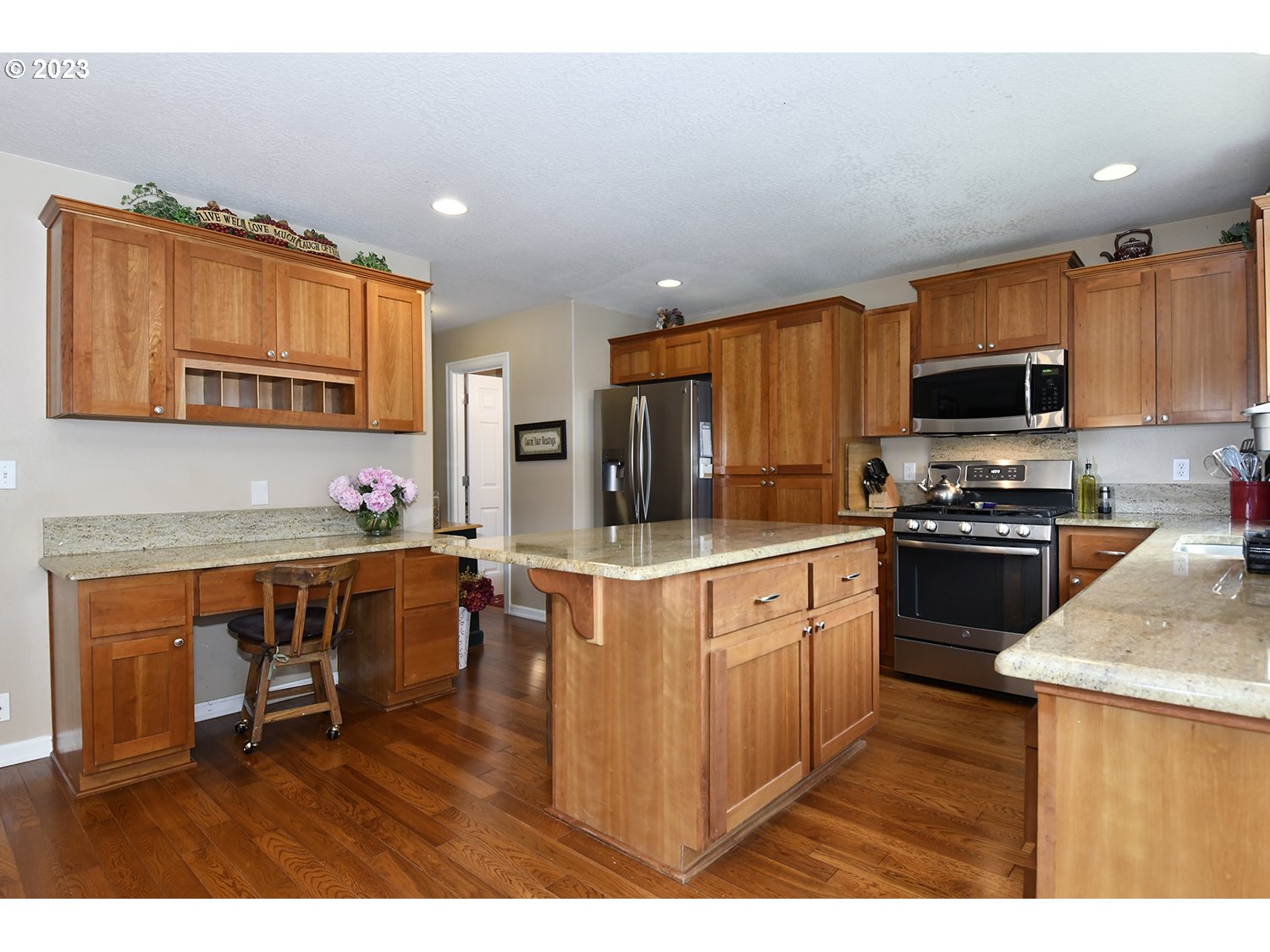 2112 Northwest 10th Street Battle Ground, WA 98604 - Photo 14 of 29 a kitchen with stainless steel appliances kitchen island granite countertop a stove refrigerator and microwave
