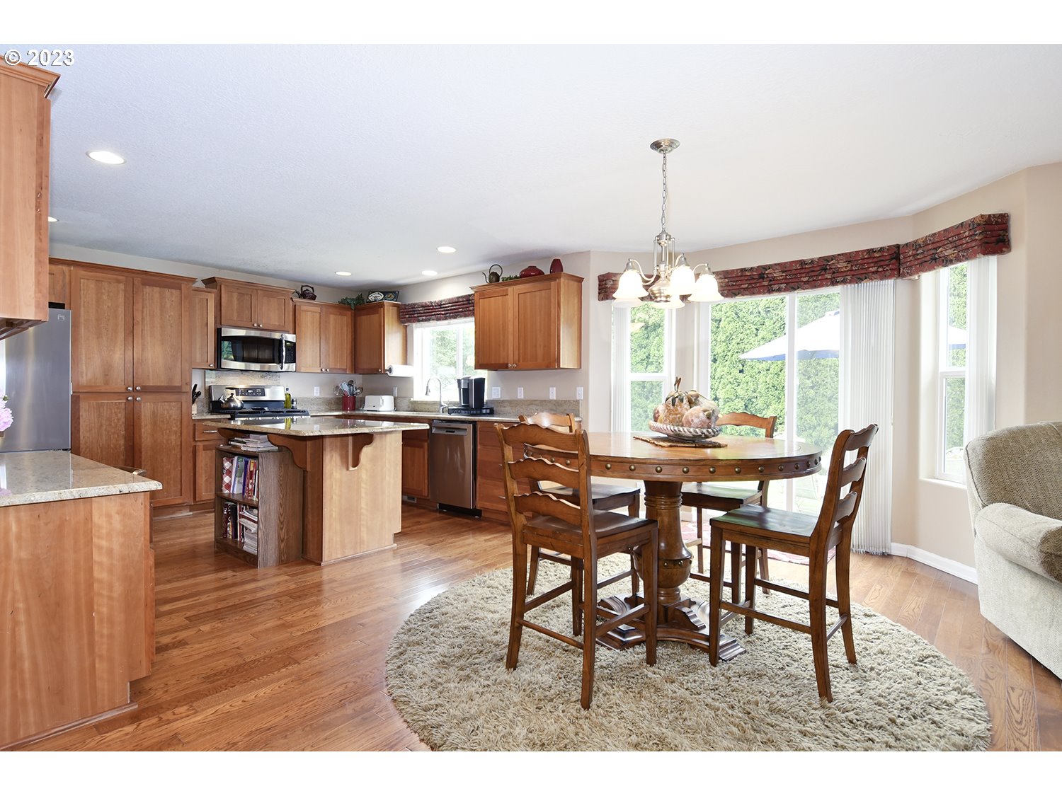 2112 Northwest 10th Street Battle Ground, WA 98604 - Photo 15 of 29 a kitchen with stainless steel appliances granite countertop a stove a refrigerator a kitchen island a dining table and chairs