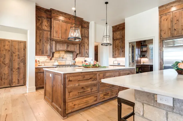 a view of a living room with a floor to ceiling window and wooden floor