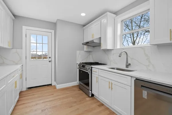 a kitchen with stainless steel appliances granite countertop a sink a stove a refrigerator and cabinets