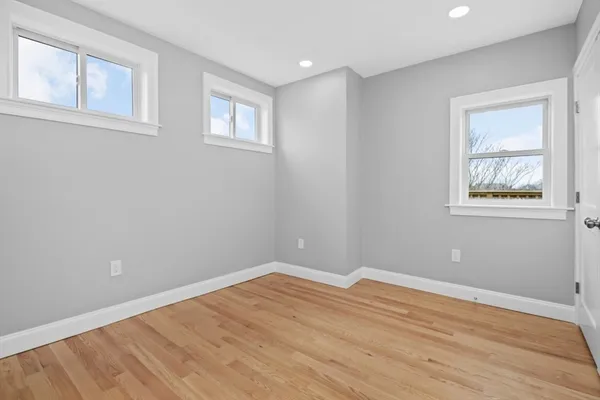 a view of empty room with wooden floor