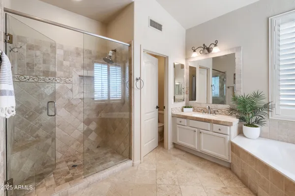 a spacious bathroom with a sink double vanity granite and a large mirror
