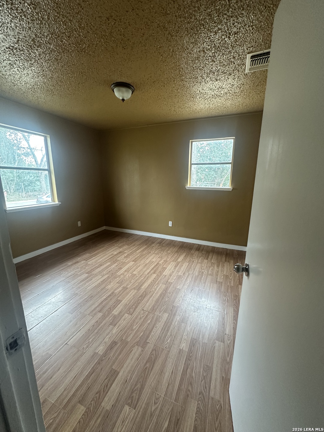 510 Riley Street Seguin, TX 78155 - Photo 17 of 24 an empty room with wooden floor and windows