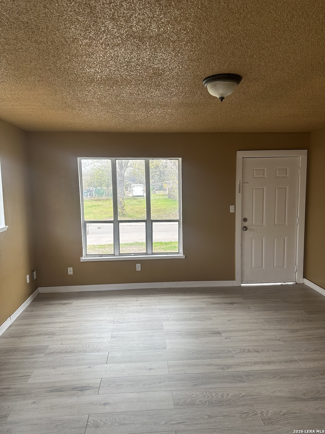 510 Riley Street Seguin, TX 78155 - Photo 4 of 24 a view of an empty room with wooden floor and a window