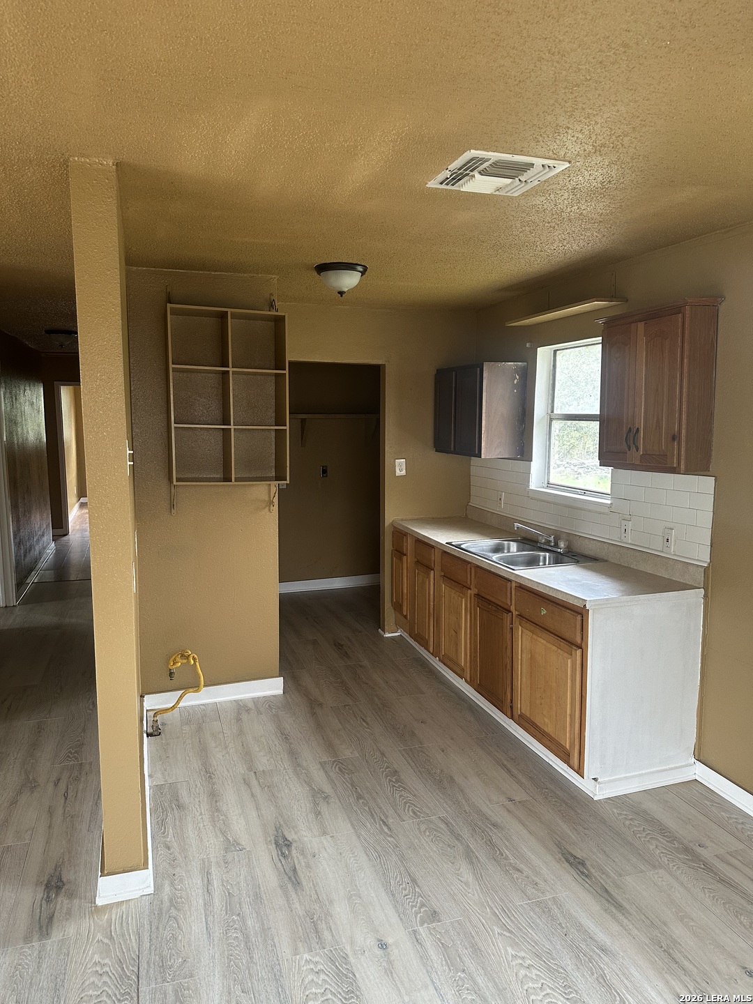 510 Riley Street Seguin, TX 78155 - Photo 5 of 24 a large kitchen with kitchen island a sink dishwasher stove and white cabinets with wooden floor
