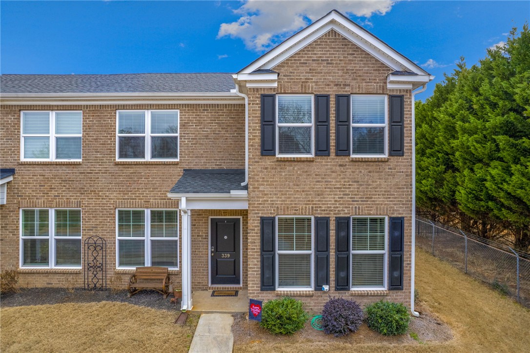 This classic brick townhome features traditional shutters and a welcoming front entrance.