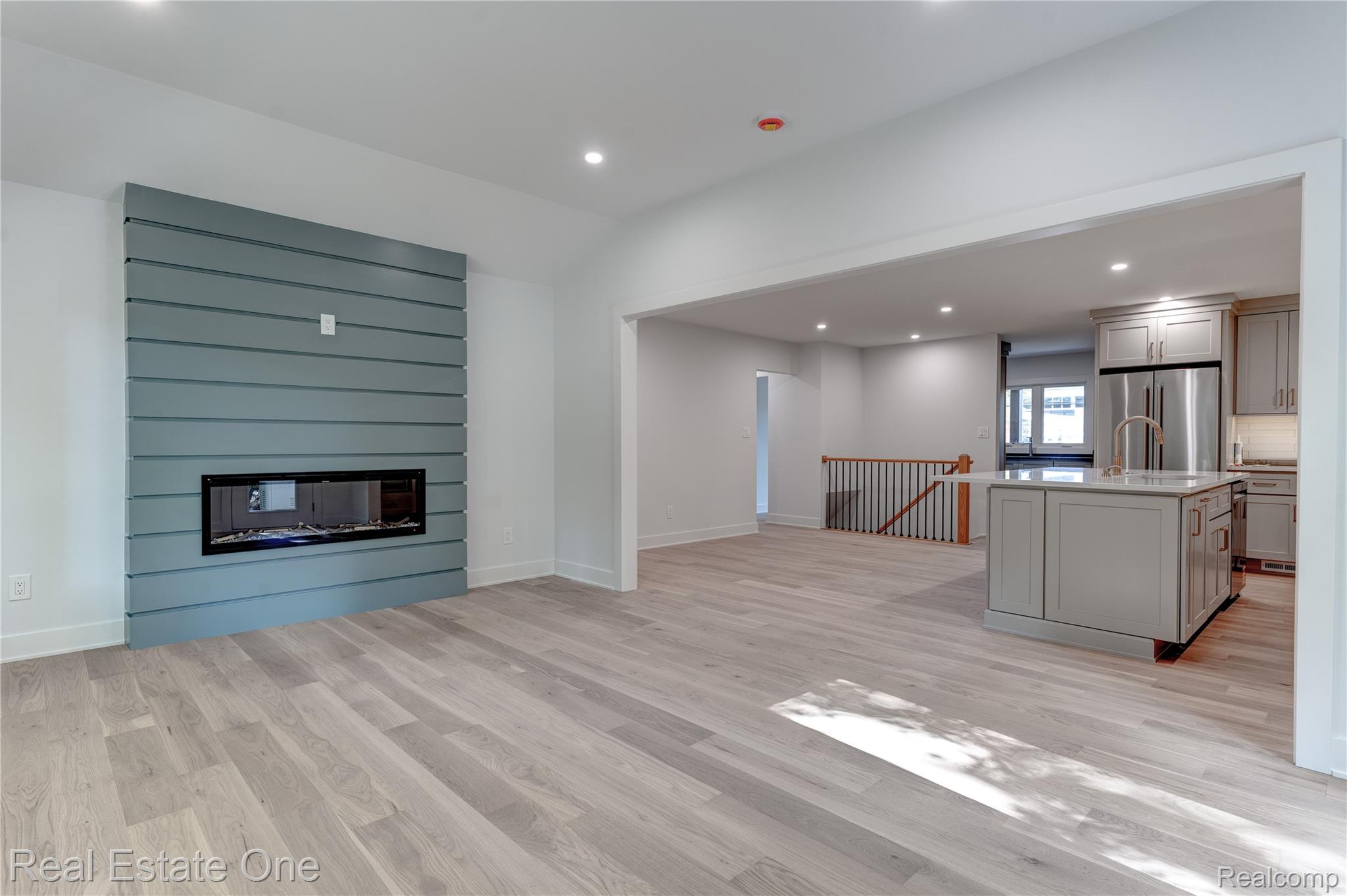 786 South Cranbrook Road Bloomfield Hills, MI 48301 - Photo 11 of 38 Unfurnished living room featuring recessed lighting, a large fireplace, light wood finished floors, and lofted ceiling