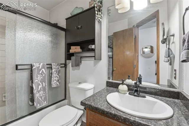 a bathroom with a granite countertop toilet sink and mirror