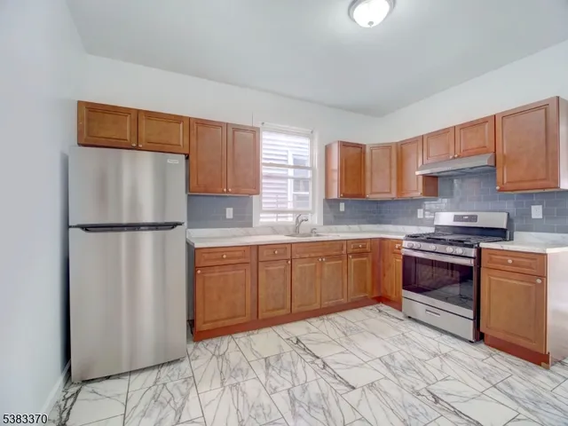a kitchen with stainless steel appliances granite countertop a refrigerator sink and cabinets
