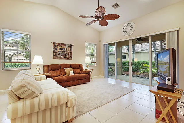 a living room with furniture a flat screen tv and a large window