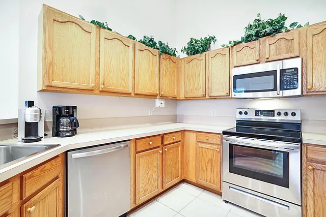 a kitchen with cabinets appliances a sink and a counter top space