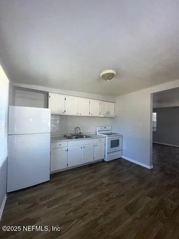 a kitchen with granite countertop a stove and a refrigerator