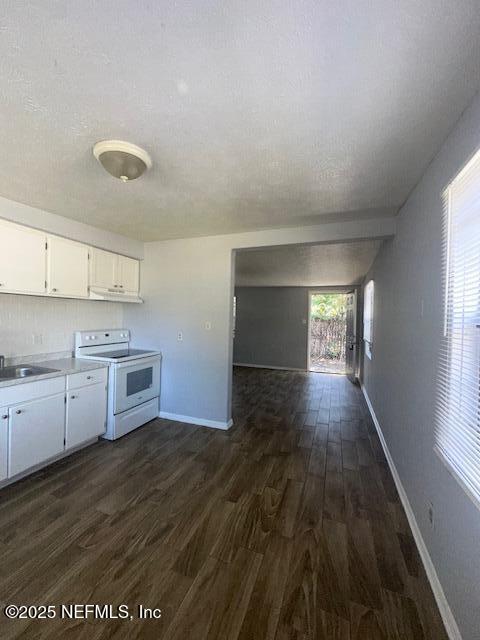 3254 Phyllis Street Jacksonville, FL 32205 - Photo 7 of 11 a kitchen with granite countertop a stove a sink and white cabinets with wooden floor
