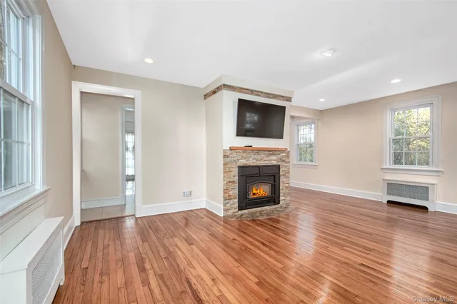 a view of empty room with wooden floor and fireplace