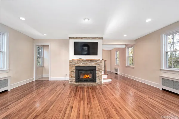 a living room with a fireplace and wooden floor