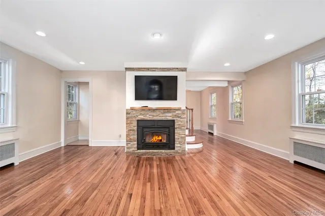 a living room with a fireplace and wooden floor