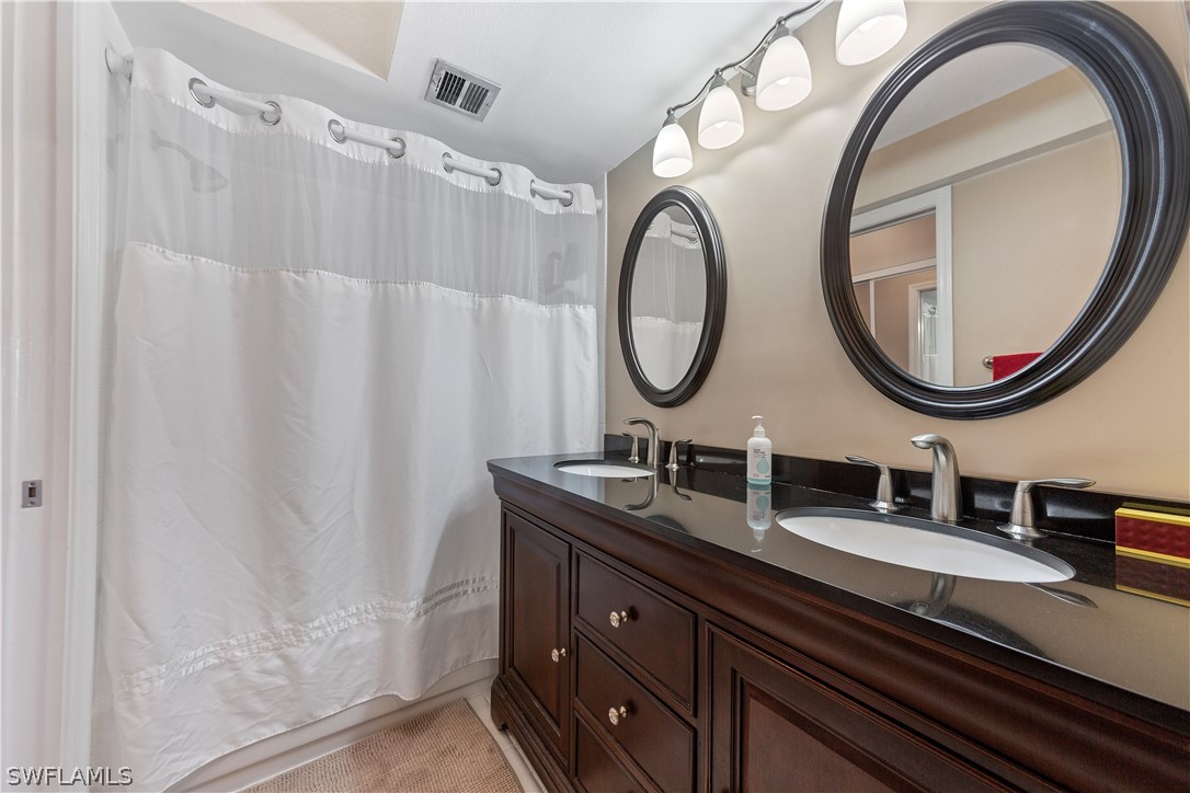 14995 Rivers Edge Court, Unit 250 Fort Myers, FL 33908 - Photo 13 of 19 a bathroom with a double vanity sink and a mirror