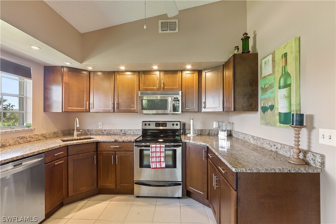 14995 Rivers Edge Court, Unit 250 Fort Myers, FL 33908 - Photo 2 of 19 a kitchen with stainless steel appliances granite countertop a sink stove and cabinets