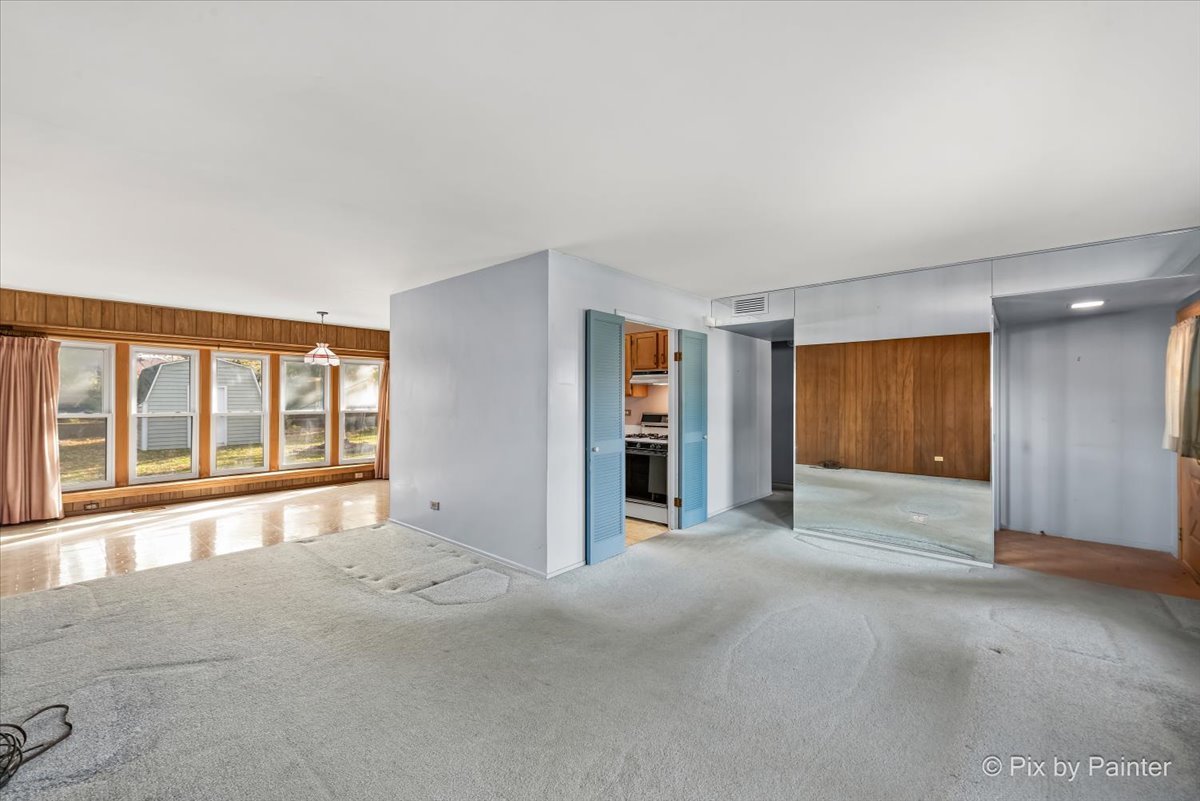 1645 Chippendale Road Hoffman Estates, IL 60169 - Photo 4 of 22 a view of an empty room with a window and a kitchen