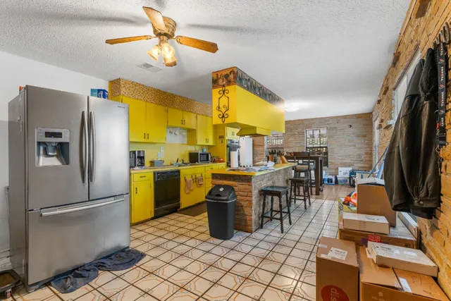a kitchen with stainless steel appliances granite countertop a refrigerator a stove and a sink