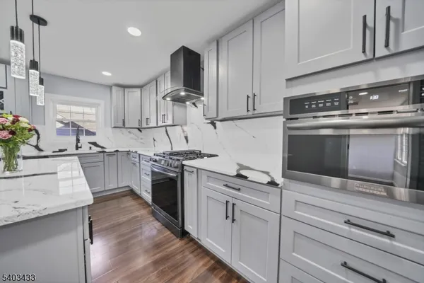 a kitchen with stainless steel appliances kitchen island granite countertop a stove a sink and a microwave